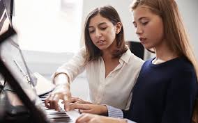 piano teacher and student
        sitting at a piano